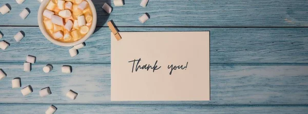 ありがとう感謝のカード碑文正引用句のテキスト木製の青の背景にコーヒーとマシュマロの白いカップとグリーティングカード 休日のコンセプト トップビュー フラットレイアウトミニマリスト — ストック写真