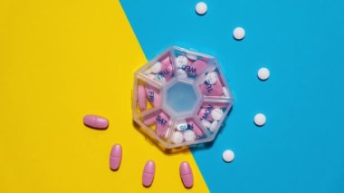 Motion Organizer 'ı durdurun. Haftalık tıbbi ilaç kutuları ve günlük haplar. Beyaz pembe haplar ve kapsüllerle ilaç alın. Evdeki günlük vitaminleri kopyala. İlaç besin takviyeleri
