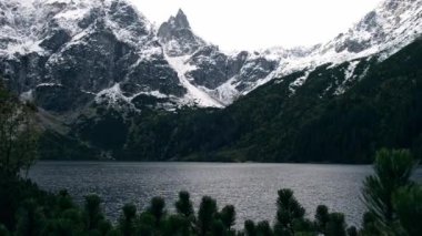 Tatra National Park, Poland. Famous Mountains Lake Morskie Oko Or Sea Eye Lake In autumn. Snow covered mountain peaks on background. Blue water nature landscape 4k