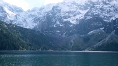 Tatra National Park, Poland. Famous Mountains Lake Morskie Oko Or Sea Eye Lake In autumn. Snow covered mountain peaks on background. Blue water nature landscape 4k