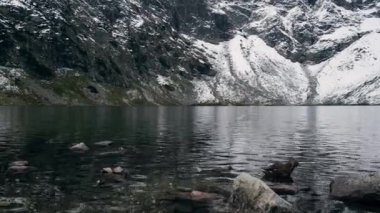 Czarny Staw under Rysy, Mountain lake pond, Tatry National Park, Poland. Snow covered mountain peaks. Winter adventure tourism attraction 