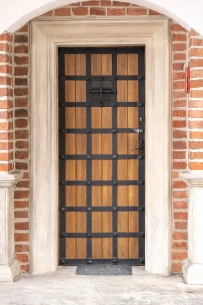 Old wooden brown house door. Gorgeous wooden door in the streets Krakow Poland. antique wooden front door with wrought-iron hinges and hook