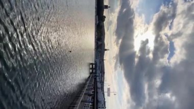 Polonya 'nın Sopot kentindeki Baltık Denizi' nde güneş yansımaları görülüyor. Güneşli yaz gününün dikey görüntüleri. Bulutlu bir sonbahar akşamı. Su dalgaları. Turistik cazibe