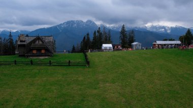 Tatra Dağları 'nın altındaki Zakopane kasabasının havadan görünüşü Gubalowka sıradağlarından alındı. Drone High dağları ve yeşil tepeler yazın veya ilkbaharda. Polonya 'da manzaralı dağ manzarası. Seyahat