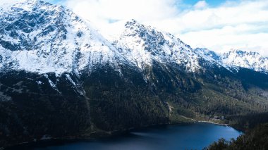 Polonya Tatry dağlarındaki Morskie Oko Karlı Dağ Kulübesi 'nin yakınındaki Kara Göl' de bulunan Çardak Staw modülü Rysamy veya Black Pond Gölü, insansız hava aracı manzarası, Zakopane, Polonya. Gökyüzü manzaralı güzel yeşil tepeler ve dağlar