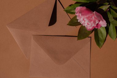 Greeting or invitation card mockup with envelope Blank paper card with copy space, peony flower with sunlight shadows. Top view, flat lay minimalist aesthetic luxury bohemian business branding concept