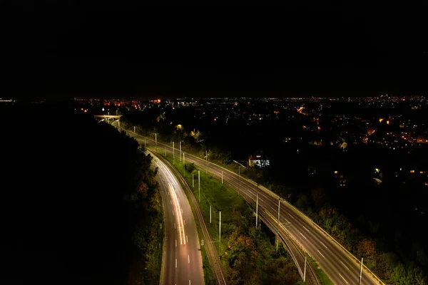 从上往下看路 浪漫的夜间航拍汽车旅行的照片 城市里夜晚道路上的灯光 背景景色宜人的道路无人驾驶景观 有轨电车背景 — 图库照片