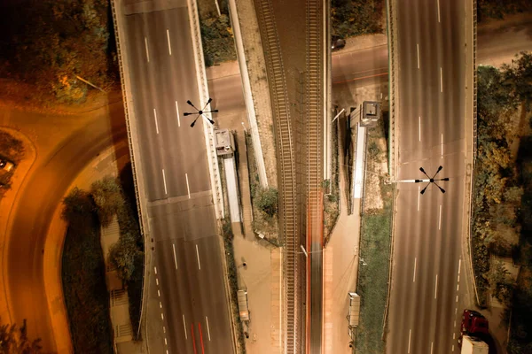 stock image Top down view to road. Romantic night aerial photo of cars traveling. The light on the road at night in city. Background scenic road drone view. Tram railways background