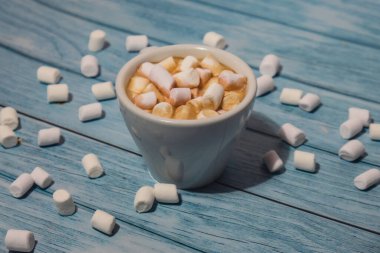 Close up of Cup hot chocolate marshmallows cacao. Cozy Coffee with marshmallows on wooden blue background. Copy space for text. Wallpaper design. Sweet unhealthy food 