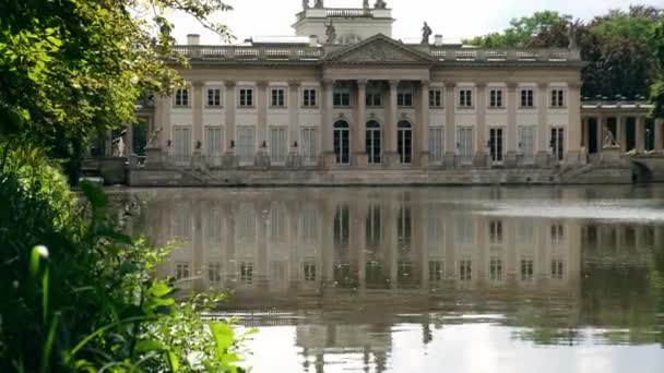ワルシャワのLazienki公園観光地の島のバス古典主義宮殿 ポーランド ワルシャワのLazienkiロイヤルバスパーク 鏡湖の反射 夏の自然バロック様式の柱 — ストック動画