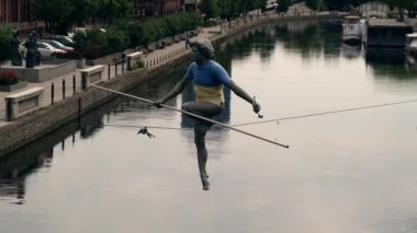 Brda river in Bydgoszcz, Man crossing a river sculpture , of a man balancing on a wire, old granary building, Kuyavian-Pomerania. Old town with reflection in Brda River Bydgoszcz, Poland. Old town