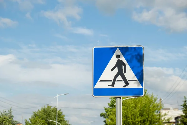 Vertical signage of crosswalk over cloudy sky, road sign pedestrian crossing. Attention road sign. Outdoors