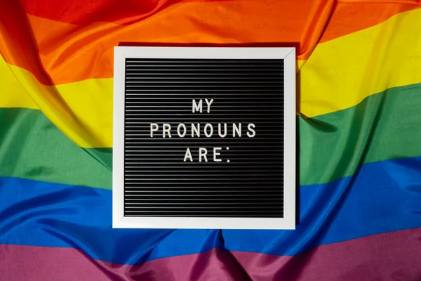 stock image MY PRONOUNS ARE text Neo pronouns concept on Rainbow flag background gender pronouns. Non-binary people rights transgenders. Lgbtq community support assume my gender, respect pronouns tolerance equal