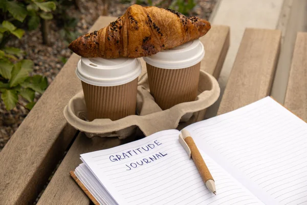 Writing Gratitude Journal on wooden bench. Coffee and croissants morning routine. Today I am grateful for. Self discovery journal, self reflection creative writing, self growth personal development
