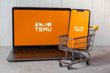 Gdansk, Polonya - Mart 2023 Temu uygulama simgesi MacBook Apple bilgisayar dizüstü bilgisayarı ve alışveriş arabalı cep telefonu ekranında. Çin merkezli Pinduoduo e-ticaret platformunun Temu yan kuruluşu. İnternetten alışveriş