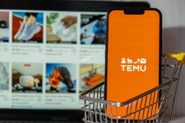 Gdansk, Polonya - Mart 2023 Temu uygulama simgesi MacBook Apple bilgisayar dizüstü bilgisayarı ve alışveriş arabalı cep telefonu ekranında. Çin merkezli Pinduoduo e-ticaret platformunun Temu yan kuruluşu. İnternetten alışveriş