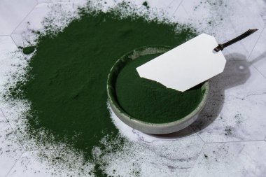 Mavi-yeşil yosun klorella ve boş kağıt notla dolu kasede spirulina tozu fotokopi alanı oluşturur. Süper toz. Doğal alg takviyesi. Detoks süper yiyecek içeceği kokteyli. Gıda takviye kaynağı