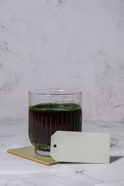 Blue-green algae Chlorella and spirulina powder drink with empty paper note copy space. Super powder. Natural supplement of algae. Detox superfood drink cocktail. Food supplement source of protein and