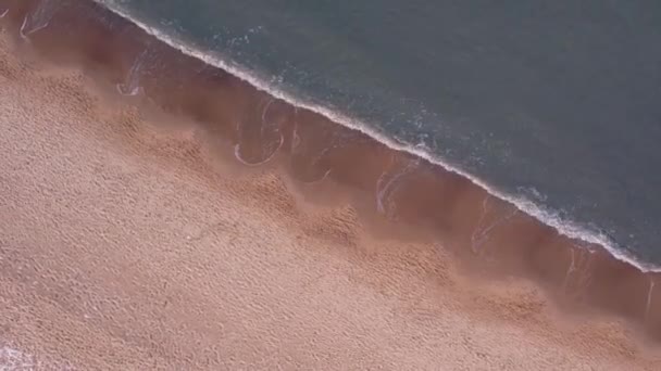 Rotation Hiver dans la mer Baltique froide plage enneigée à Gdansk. Vue aérienne de la plage enneigée et des dunes sombres vagues de mer calme paysage naturel capturé avec un drone. Tourisme d'hiver en Pologne