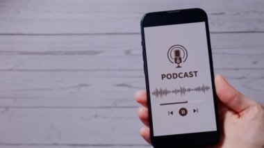 Elinde cep telefonu olan tanınmayan bir kadın internet sitesi uygulamasını kablosuz kulaklıkla dinliyor. Ses iyileştirme, ses terapisi sağlık ritüelleri, olumlu ruh sağlığı alışkanlıkları.