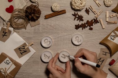 Tanımlanamayan genç bir kadın çay mumlarına numara çiziyor. Ev yapımı takvim yapan kadın kendi elleriyle adım adım kendi işini kendi başına hallediyor. Noel konseptine hazırlık