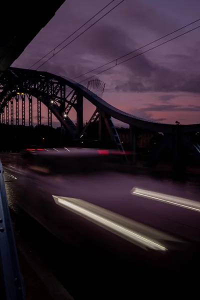 クラクフの橋で夜の車の照明を使用しています 街路灯だ 夜の高速道路の街 長時間露光写真ナイトロード 道路上の赤い光の歩道の色のバンド 背景壁紙 — ストック写真