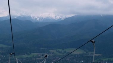 Chair lift with view of autumn mountains. Cable chair ski lift in Zakopane mountain resort Poland. Scenic autumn landscape. Ropeway, empty ski lift chairs Moving ski lifts or funiculars on the