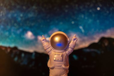 Evrendeki plastik oyuncak astronot gezegenlerin arka plan kopyalama uzayı. Dünya dışı seyahat kavramı, özel uzay adamı ticari uçuşları. Uzay görevleri ve Sürdürülebilirlik