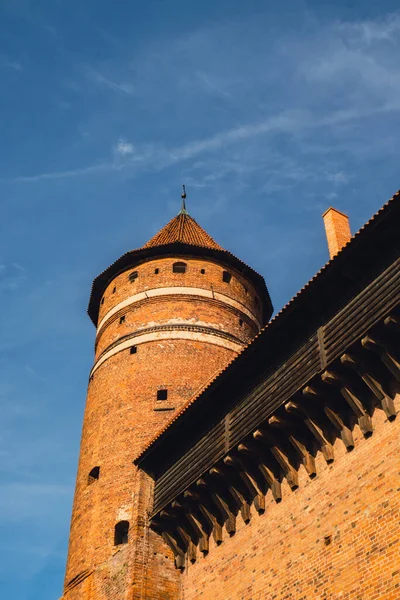 stock image Old teutonic castle in Olsztyn Gothic Crusaders castle, tourist attraction of eastern Poland. Yellow orange brick wall with wooden decoration. Historical castle