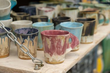 Gdansk, Polonya - 9 Ağustos 2022 Polonya kültürü - sokak pazarında halk ürünleri sergileniyor. Elle boyanmış kupalar. Gdansk Renkli Kupa Koleksiyonu 'ndaki Dominik Fuarı hediye dükkanının tezgahında.