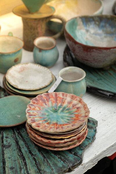 Gdansk, Poland - 9 August 2022 Polish culture - showcase with folk products on the street market. Hand painted mugs. Dominics Fair in Gdansk Colorful collection of mugs on the counter of gift shop in