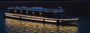 Gdansk Polonya Mayıs 2022 Turistik restoran gemisi Gdansk 'ta eski bir kasabaya yelken açıyor. Akşamüstü deniz kıyısındaki kafe. Turistlerle dolu bir gemi Granary Adası yansıması için nehir kıyısına doğru yola çıkıyor.