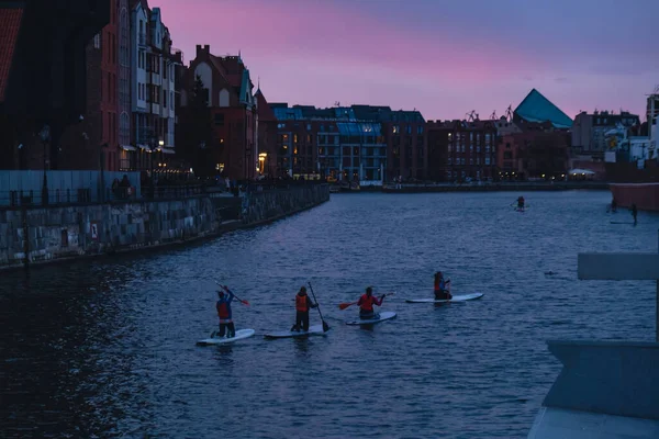 波兰格但斯克 Gdansk Poland 2022年3月 一群冲浪小组站在船桨板上 在莫特拉瓦市和古城黄昏的运河中一起划桨 旅游景点户外活动 — 图库照片
