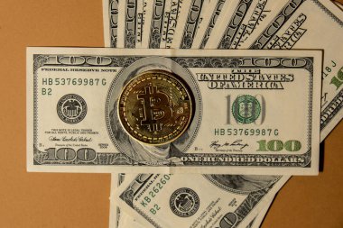 Bitcoin gold coin on bills of 100 dollars American currency. Bitcoin mining trading concept. BTC golden money. Worldwide virtual internet Cryptocurrency or crypto digital payment system. Digital coin