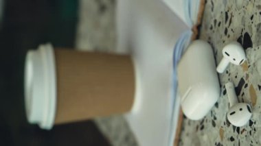 Dikey yakınlaştır. Kağıt bardaktaki kahveyi geri dönüşüm için kullan. Kağıt defter ve kablosuz kulaklıkla birlikte. Model kahve molası. Ses iyileştirme, ses terapisi sağlık ritüelleri, pozitif zihinsel...