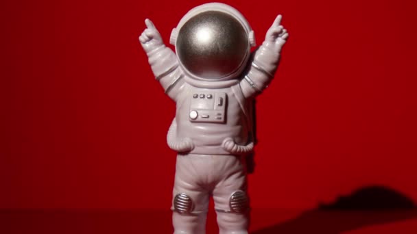 放大塑料玩具宇航员在彩色红色背景复制空间 走出地球旅行的概念 私人航天人商业飞行 空间飞行任务与可持续性 — 图库视频影像