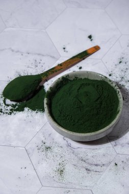 Mavi-yeşil yosun klorella ve tahta kaşıkla kasede spirulina tozu. Süper toz. Doğal alg takviyesi. Detoks süper yiyecek içeceği kokteyli. Besin takviyesi protein ve beta