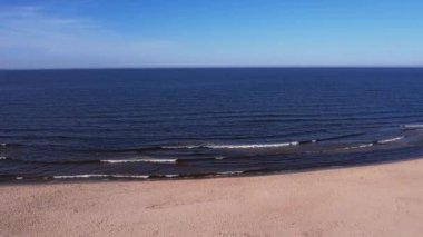 Dalgaların, deniz kıyılarının insansız hava görüntüsü. Kumsallar ve kumullar, sakin deniz dalgaları insansız hava aracıyla ele geçirilen doğa manzarası. Polonya 'da turizm