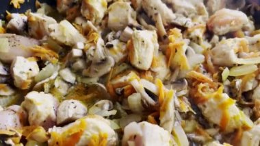 Tavuk eti ve doğranmış mantar parçalarını kızgın tavada yakın çekim. Sos içinde soğan ve havuç. Ev ve restoran mutfağı için pişirilen tarifler.. 