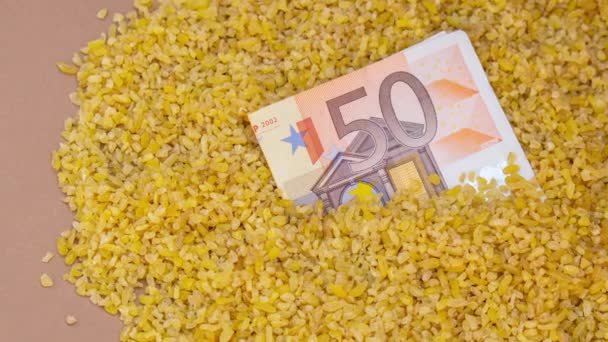 放大面额欧元纸币钞票钞票在荞麦粥 粮食作物市场的危机 荞麦食品和日用品价格或产量的上涨 — 图库视频影像
