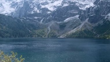 Tatra National Park, Poland. Famous Mountains Lake Morskie Oko Or Sea Eye Lake In autumn. Snow covered mountain peaks on background. Blue water nature landscape 4k