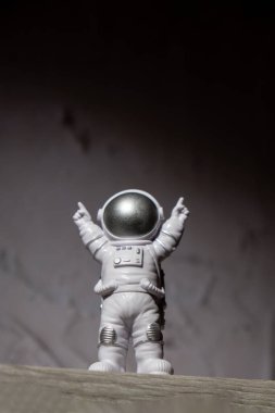 Plastic toy figure astronaut on moon concrete background Copy space. Concept of out of earth travel, private spaceman commercial flights. Space missions and Sustainability