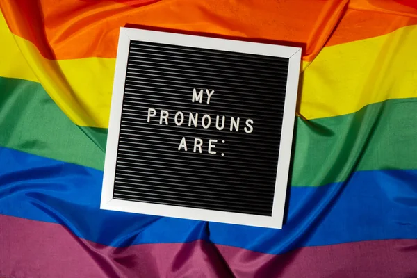 stock image MY PRONOUNS ARE text Neo pronouns concept on Rainbow flag background gender pronouns. Non-binary people rights transgenders. Lgbtq community support assume my gender, respect pronouns tolerance equal