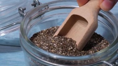 Yavaş çekim chia tohumları cam kavanoza düşer. Omega 3 yağ asitleri bakımından zengin sağlıklı süper yiyecekler. Kuru, sağlıklı, doğal bileşen. Chia taneleri düşüyor. Vejetaryen yemeği. 
