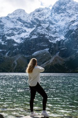 Polonya 'nın Tatry dağları Zakopane Polonya' daki Morskie Oko Karlı Dağ Kulübesi 'nde doğanın tadını çıkaran genç bir kadın. Doğanın estetik güzellikteki yeşil tepeleri. Zihinsel ve fiziksel refah açık havada seyahat eder.