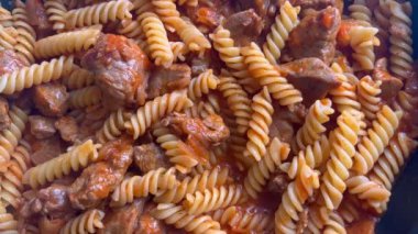 Cooking Pasta In Pan Boiling Food. Delicious Italian Bolognese spices and minced meat. Homemade hot, steamy pasta. Heating pasta with meat in frying pan. 