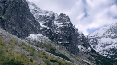 Polonya Tatry dağlarındaki Morskie Oko Gölü Karlı Dağ Kulübesi, Zakopane, Polonya. Güzel yeşil tepeler ve kara bulutlar içindeki dağlar ve Morskie Oko Gölü 'nün yansıması. Seyahat eden turist