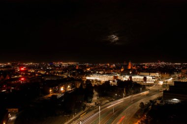 Tepeden tırnağa. Seyahat eden arabaların romantik gece hava fotoğrafı. Şehirdeki gece yoldaki ışık. Arka plan manzaralı drone görüntüsü. Tramvay demiryolları geçmişi