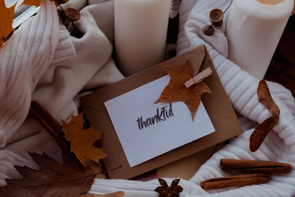 感謝のテキストグリーティングカードのコンセプト感謝祭の秋の休日を祝う窓の上の居心地の良い家大きな審美的な雰囲気暖かいですニットの白いセーターに秋の葉スパイスとキャンドル — ストック写真