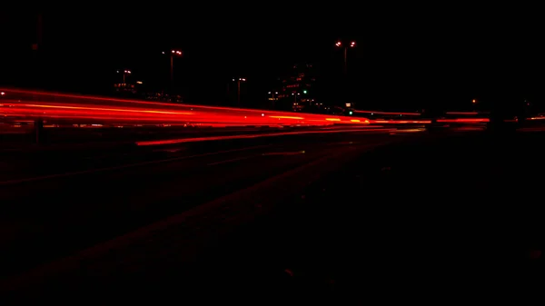 夜晚的车灯 夜路城漫漫长夜摄影路 道路上五彩斑斓的红光小径 背景墙纸调焦的照片 — 图库照片